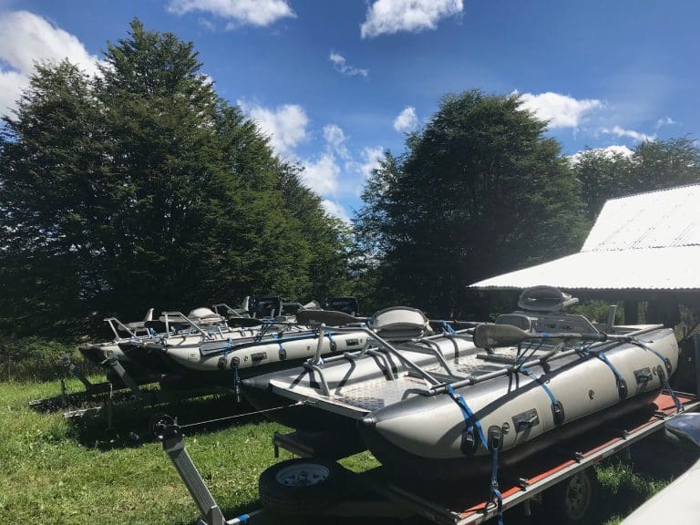Inflatable boats on trailers near trees.
