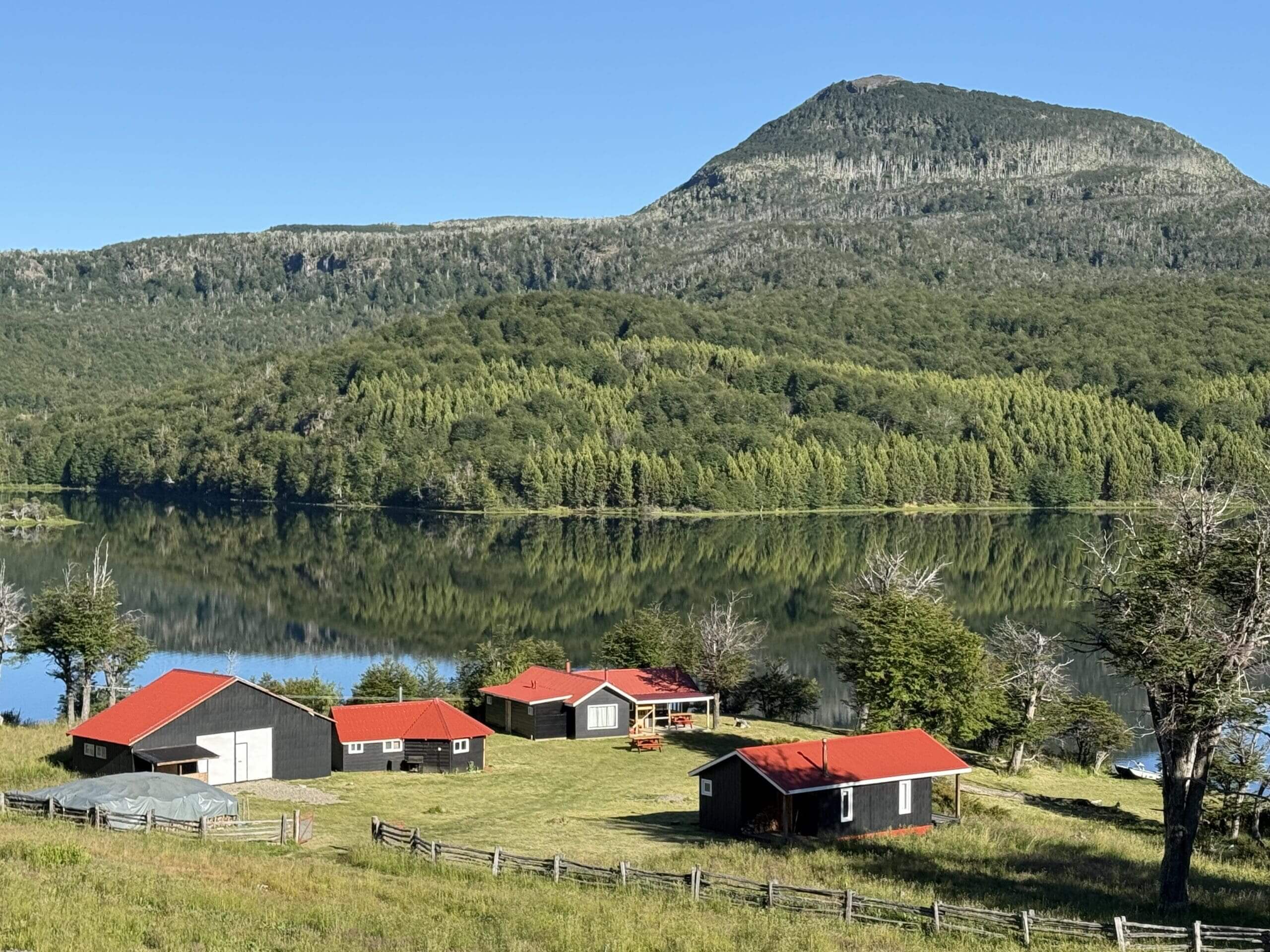 Rural cabins by lake and mountain scenery.