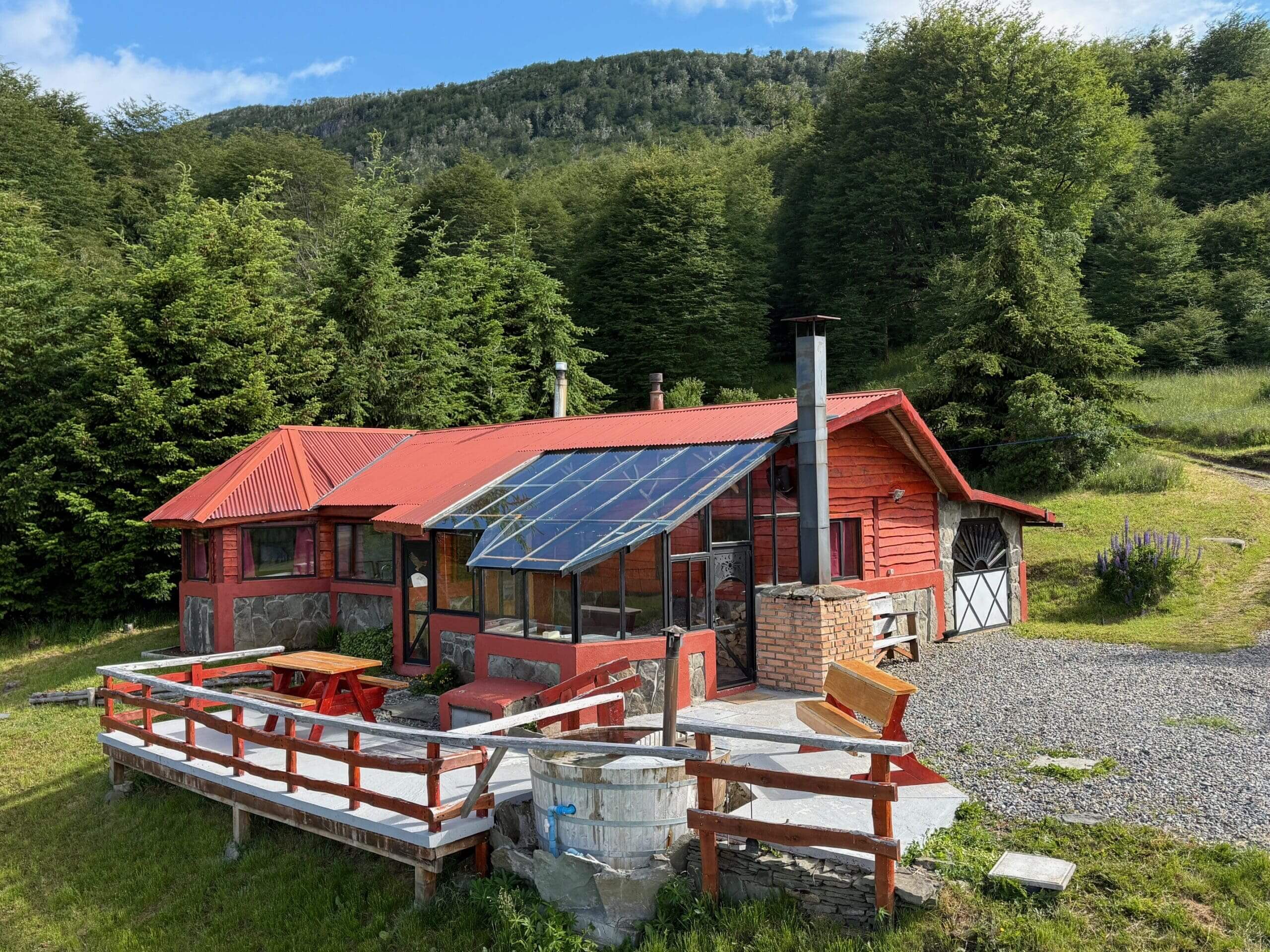 Red cabin with solar panels in forest.